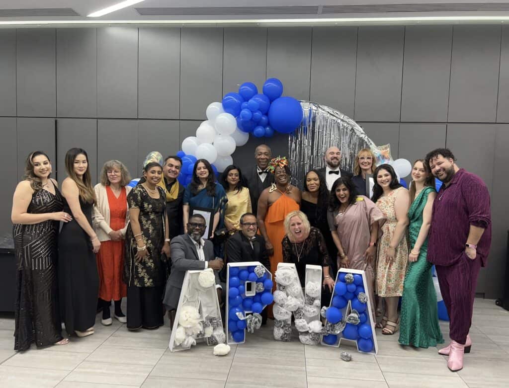 team members smiling by an APNA sign and balloons