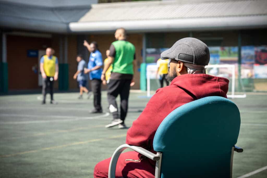 A patient sitting watching other play football