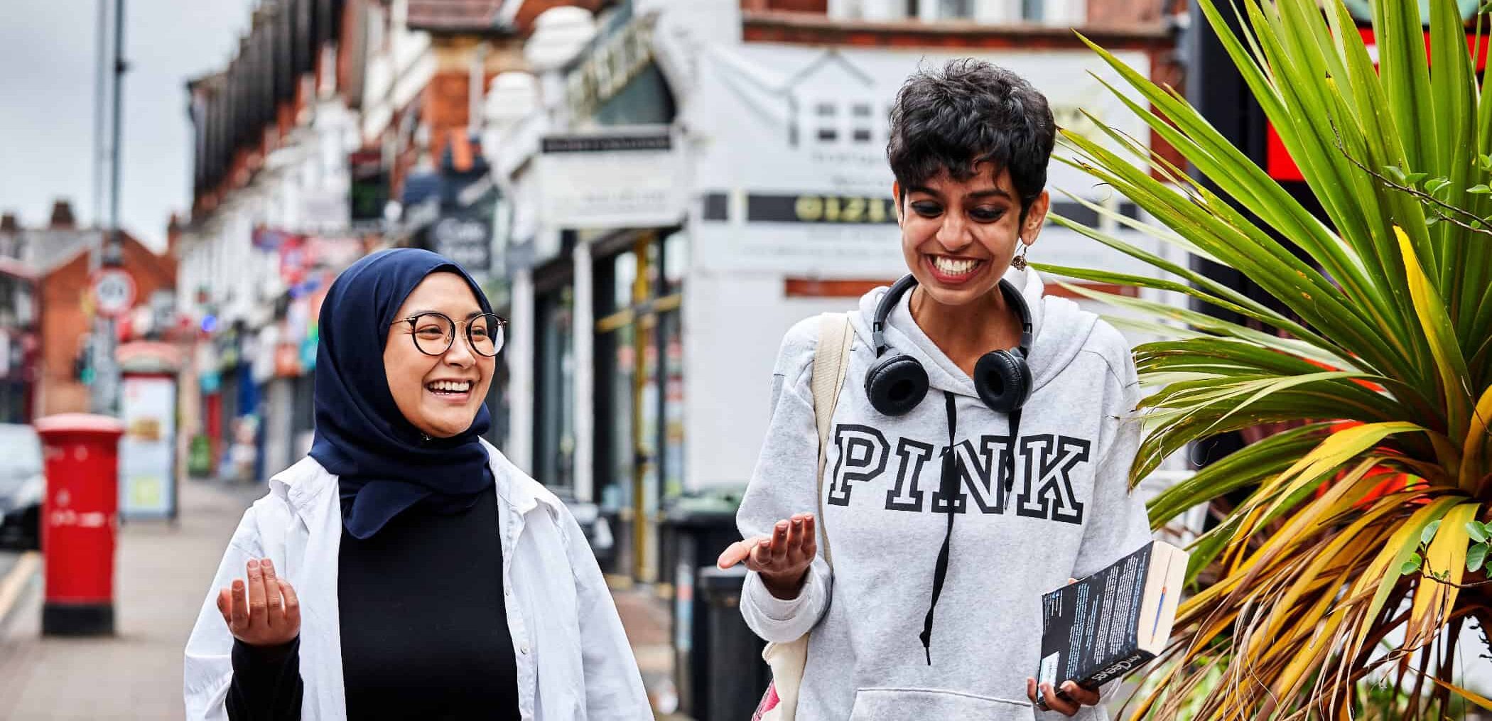 Two young women walking down the street