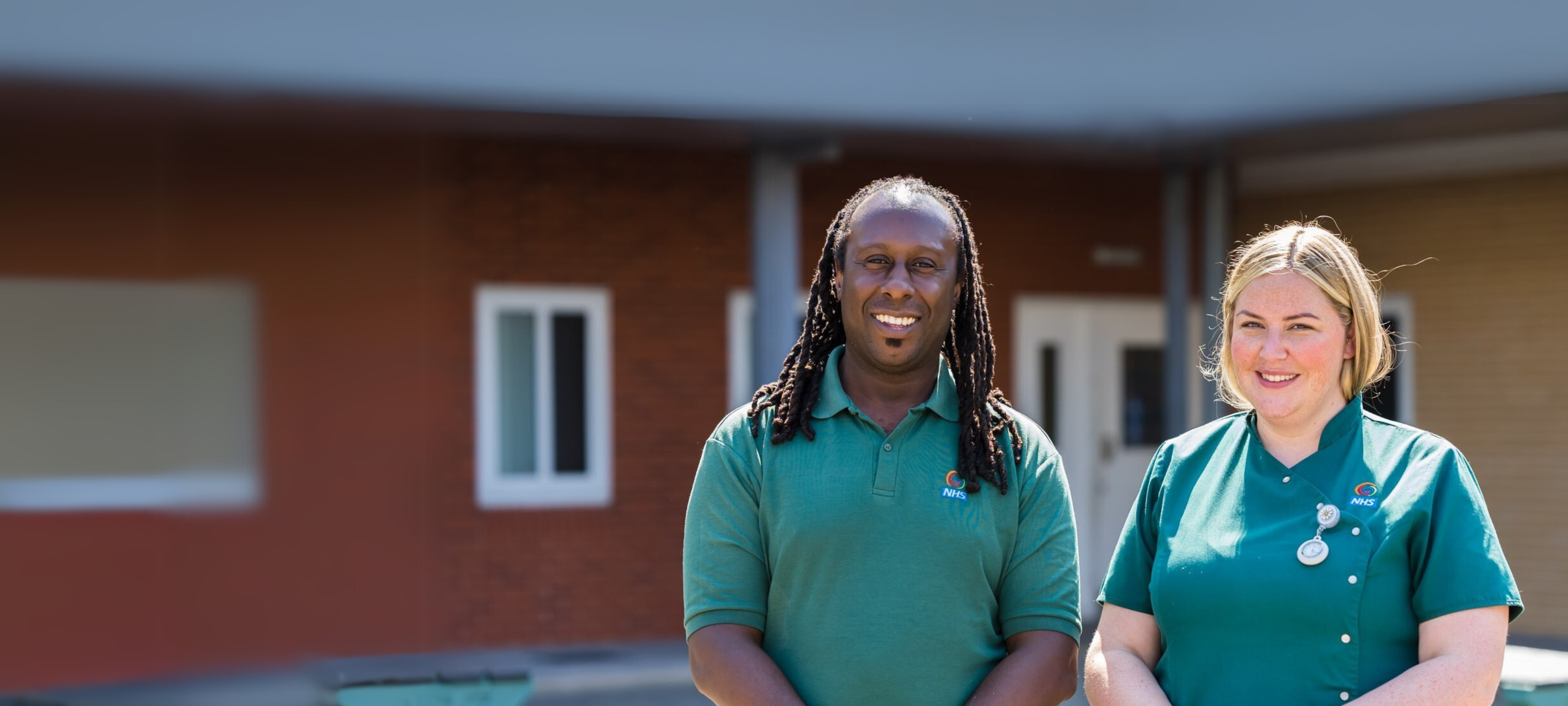 a male member of staff on the left and a female member of staff on the right smiling